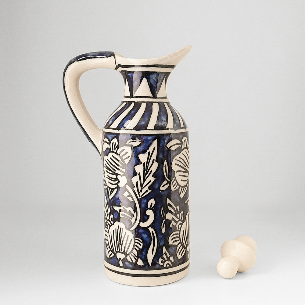 Handmade ceramic small multipurpose bottle with lid kept on the side, blue and ivory colors