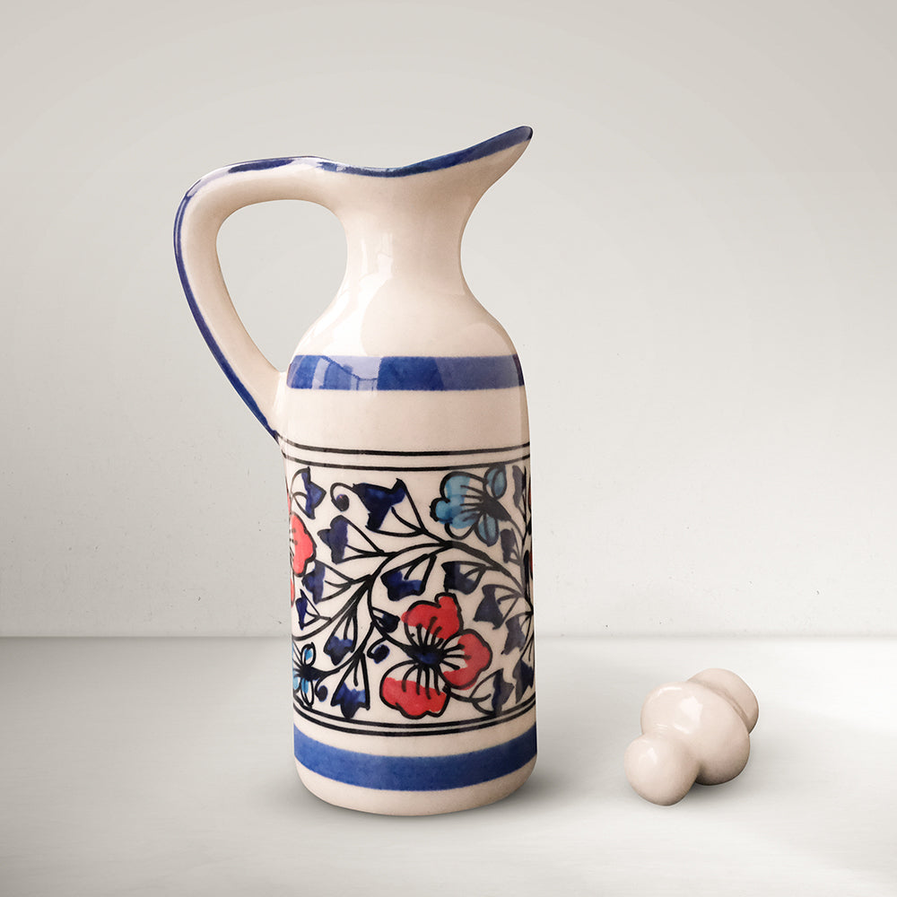 Handmade ceramic small multipurpose bottle with lid kept on the side, blue, red and ivory colors