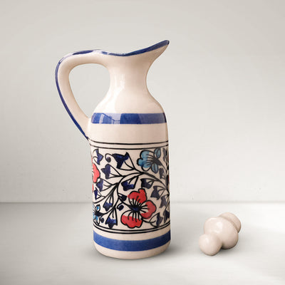 Handmade ceramic small multipurpose bottle with lid kept on the side, blue, red and ivory colors