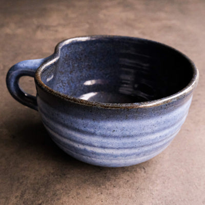 Handcrafted blue ceramic mug with speckles, shaped like an apple